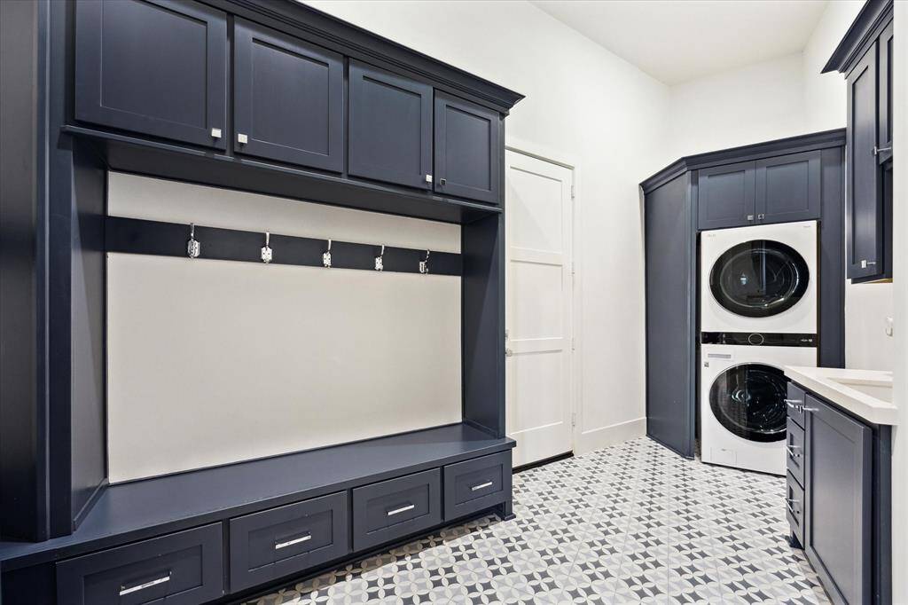 The first-floor utility room offers a stackable washer and dryer, along with a sink, providing practical and efficient laundry space.
