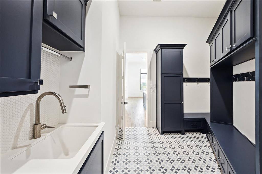 The utility room/mud room features a built-in bench with drawers, hooks, and upper cabinets perfect for everyday storage.