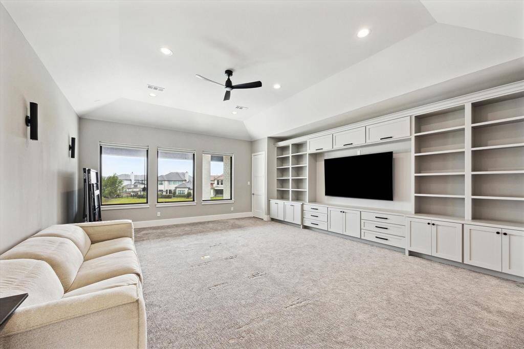The game room features custom built-ins and a spacious storage closet, all while offering stunning views of the pool and lake.