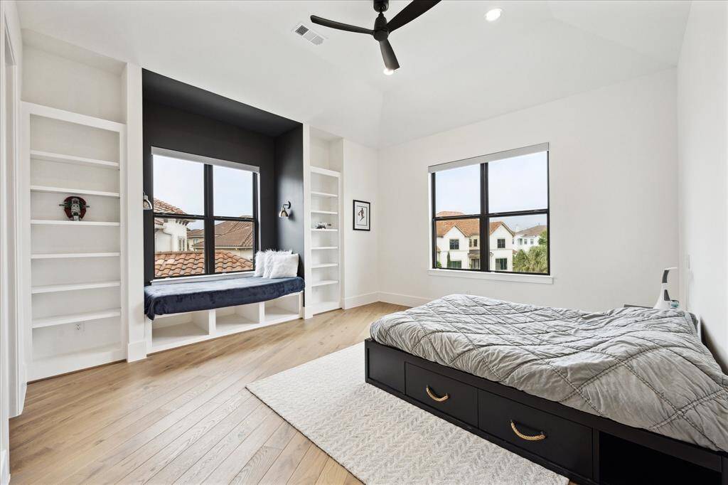 The secondary bedroom offers a cozy seating area and custom built-ins, creating a comfortable retreat.