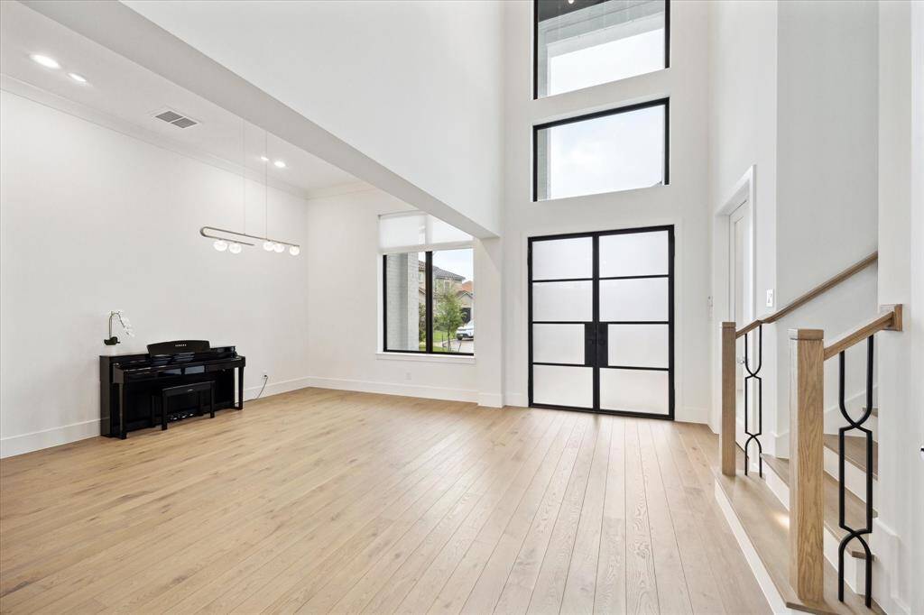 Enter through a double iron doors into an impressive double-height foyer, complemented by elegant wood floors extending throughout.