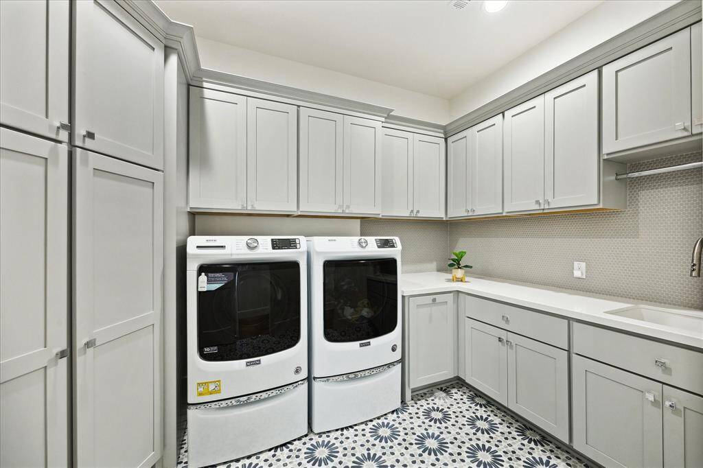 The second-floor utility room is equipped with a sink,quartz countertops and offers ample storage space.