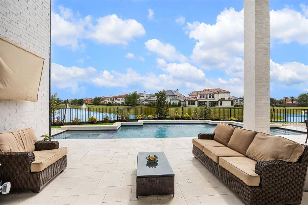 The view from the back door offers a picturesque vista, overlooking the pool and serene lake beyond.