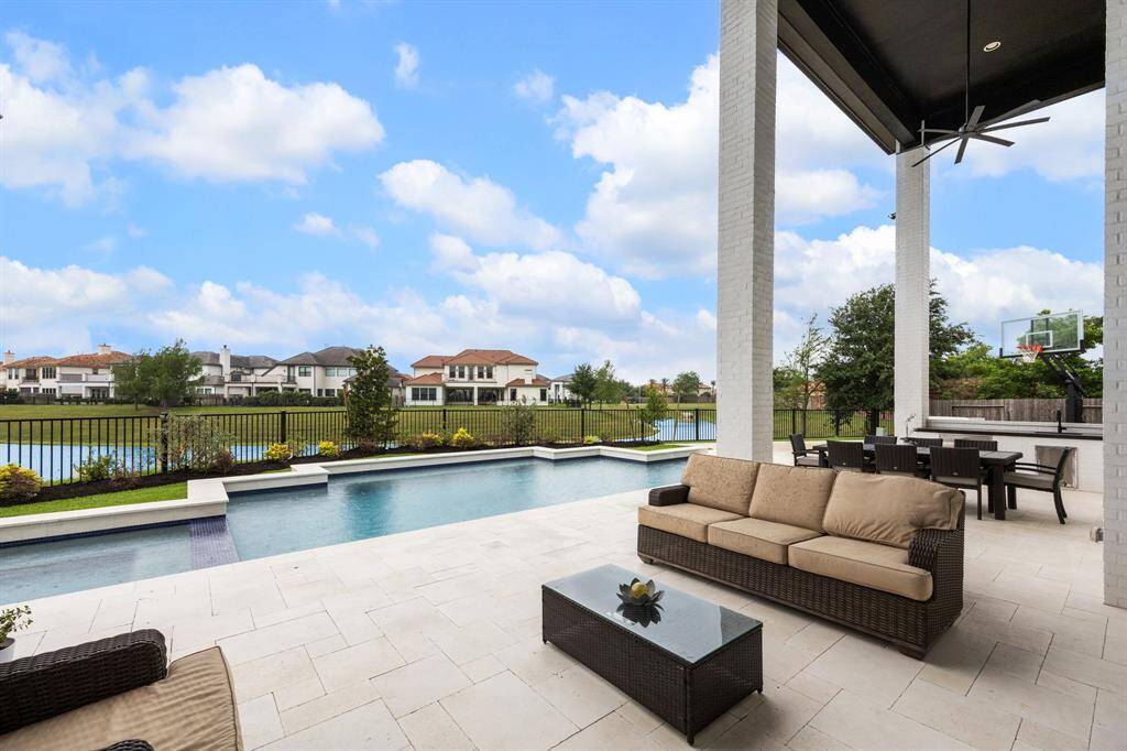The outdoor kitchen is equipped with elegant granite countertops, storage, a sink and a gas line ready for a future grill.