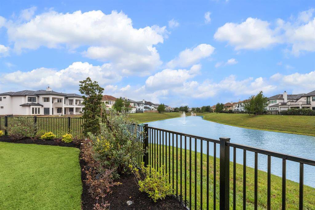The backyard feels like a serene vacation retreat, with wrought iron railings offering unobstructed views of the tranquil lake.