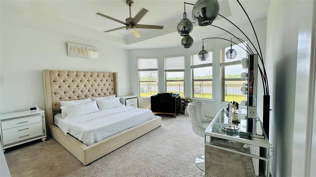 spacious primary bedroom with natural light and the best water view on the backyard