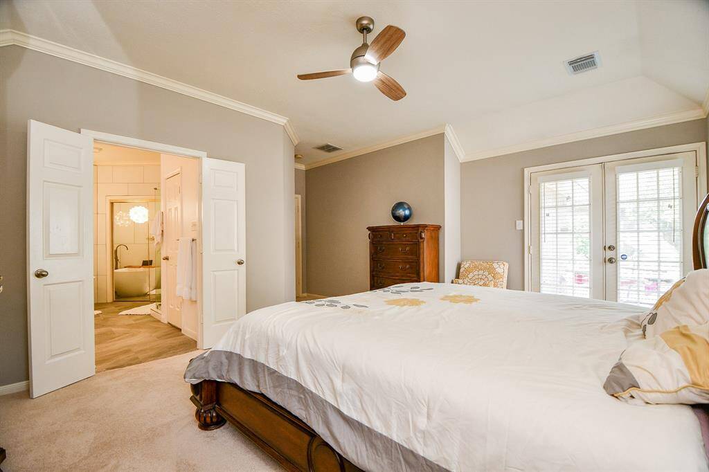 View of primary bedroom to double doors to primary bathroom