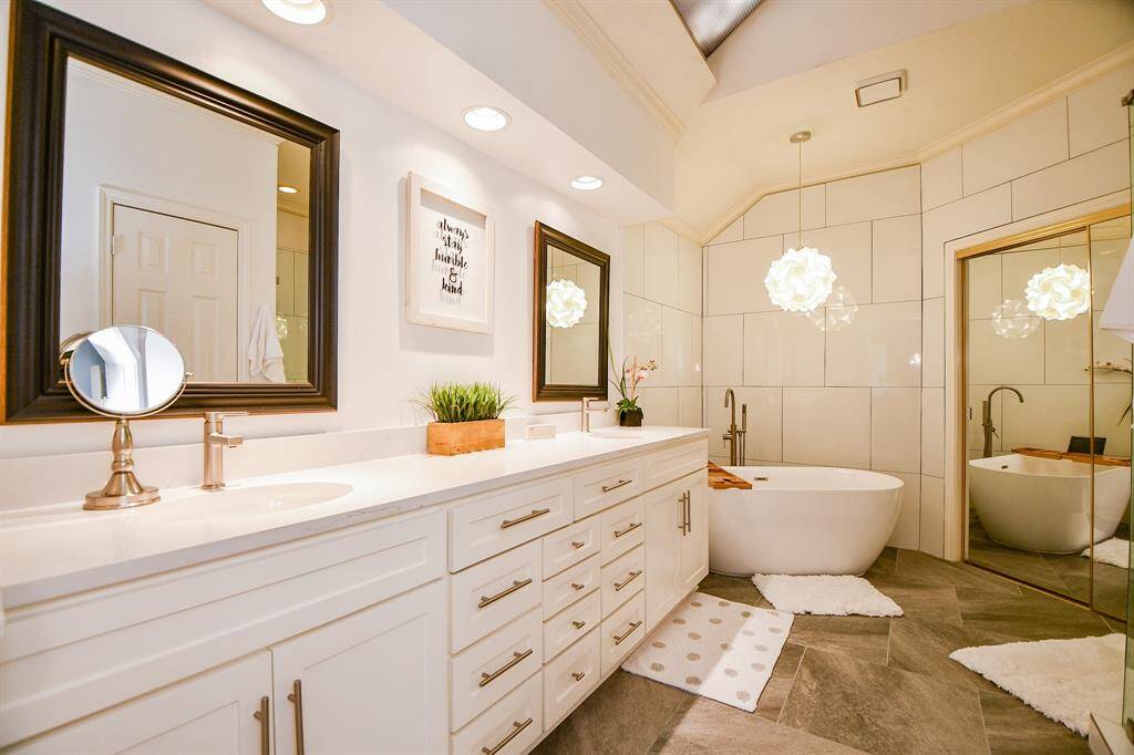 Elegant updated ensuite bathroom boasts of large vanity, double sinks, quartz countertops and soaking tub.