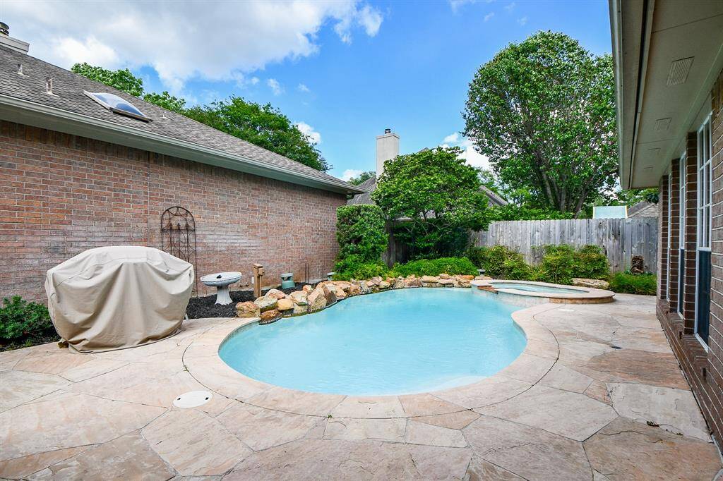 Pool/spa features lush landscaping.
