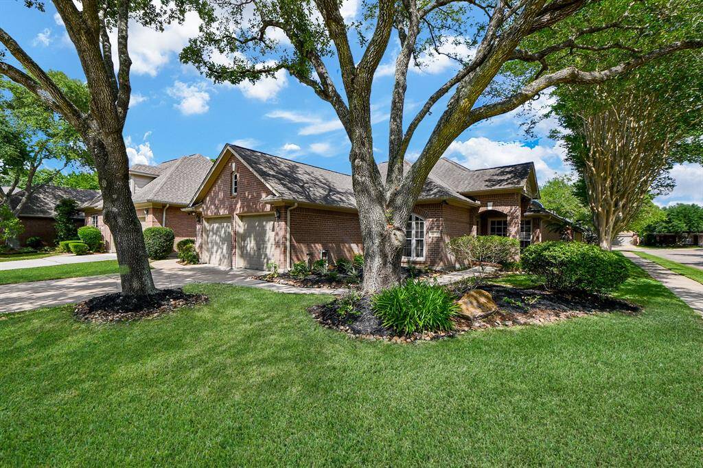 Front view of home with manicured lot and mature trees.