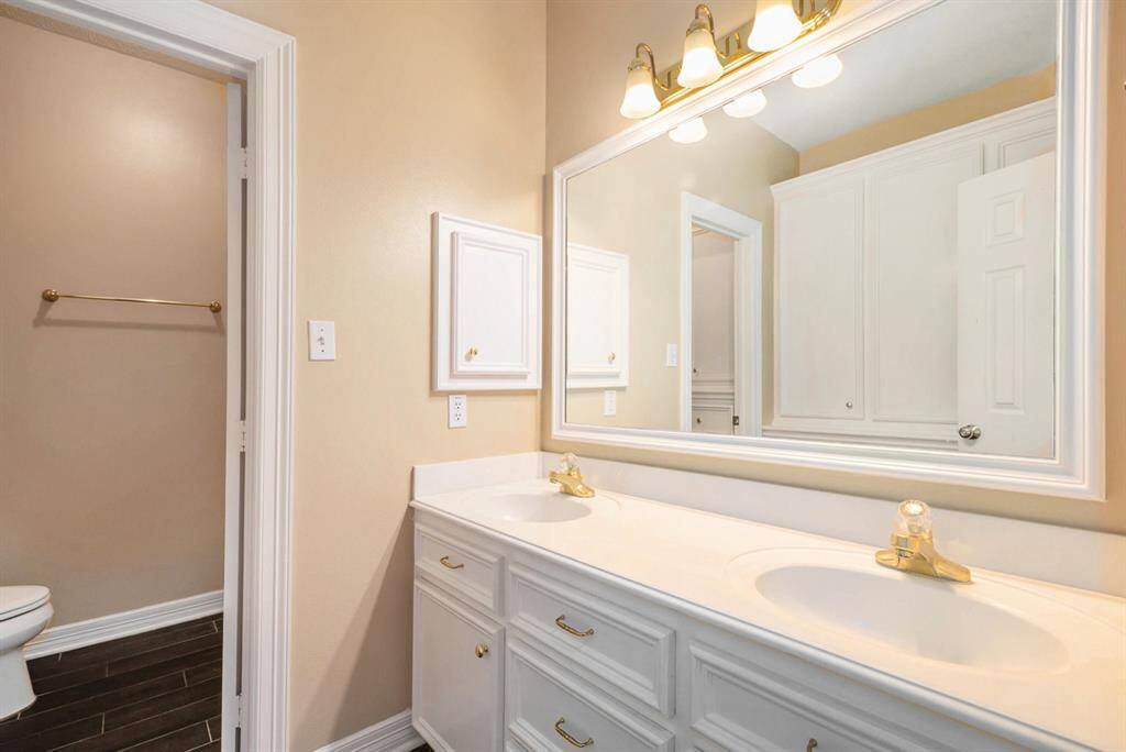 Secondary bathroom offers dual sinks, lots of storage space, and a combination tub and shower.