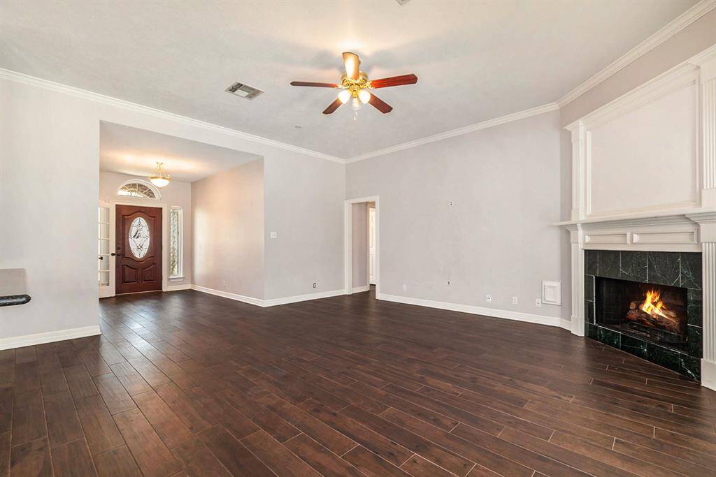 Inviting living room featuring gorgeous dark flooring and a cozy fireplace.
