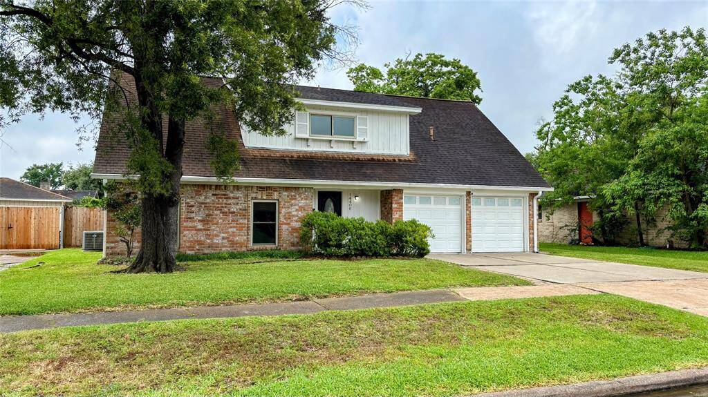 This charming two-story home includes a spacious driveway leading to a double garage. The property is surrounded by mature trees and well-maintained greenery.