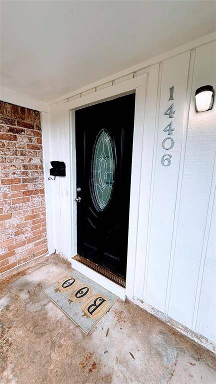 Welcoming front entrance with a stylish black door featuring an oval glass insert.