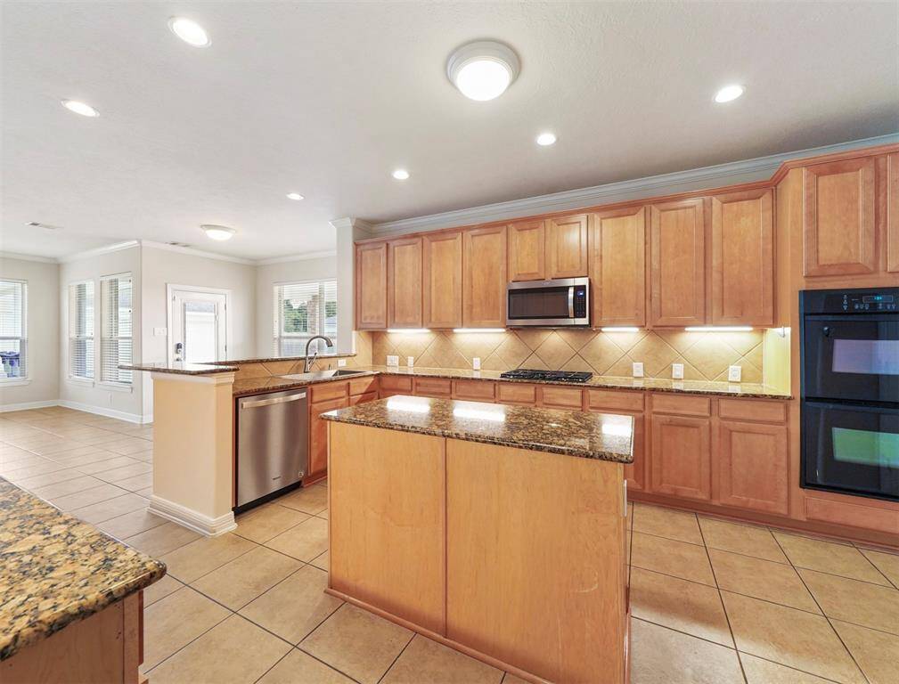 Chef's dream kitchen featuring: double ovens, island, gas stove, and breakfast bar.