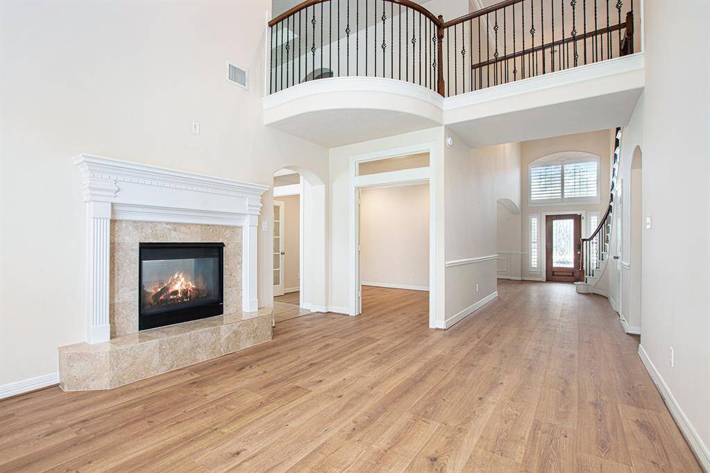 Exquisite formal living room shares a dual sided fireplace with the family room.