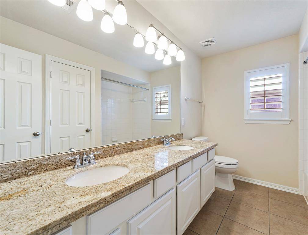 Upstairs secondary bathroom with granite countertops and two sinks.