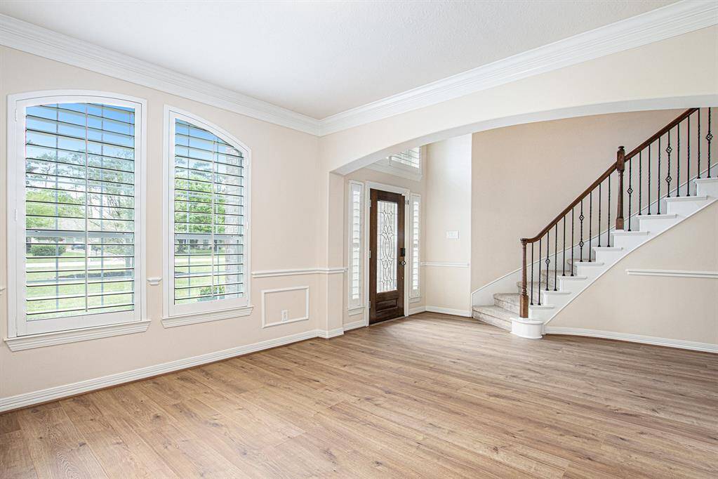 Formal dining room has chair railing, plantation shutters, crown molding, and access to the kitchen.
