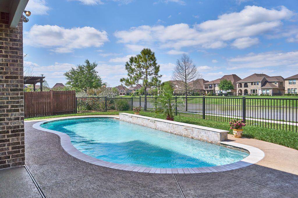 Refreshing private pool in the back yard will cool you down during Houston summers. The Travertine coping and waterfall backdrop adds elegance and ambiance.