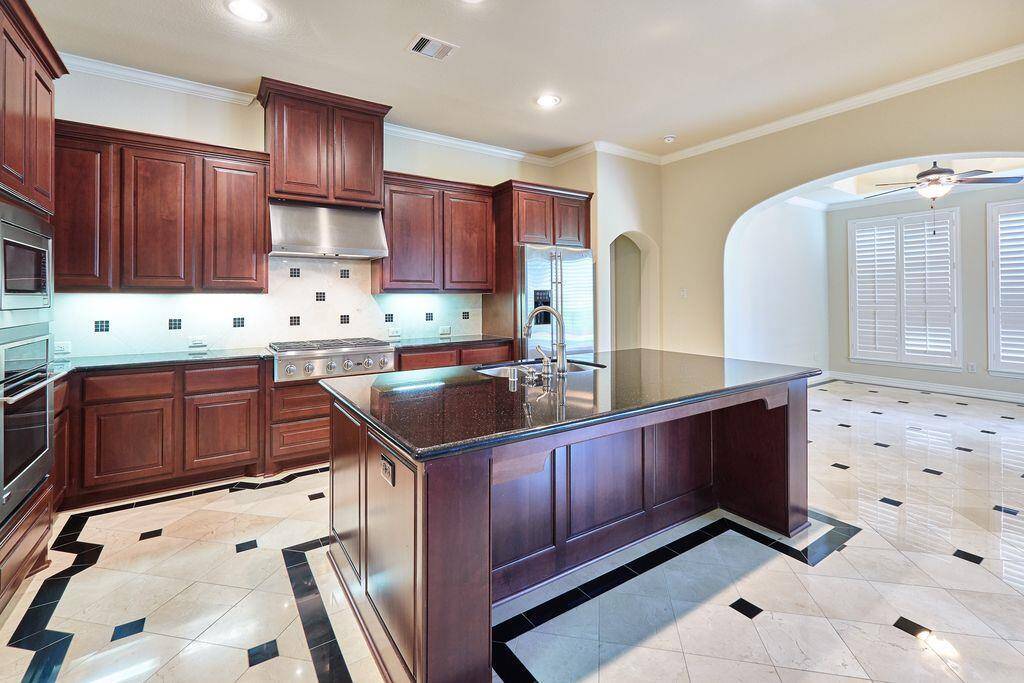 Gourmet kitchen features custom Cherry cabinets and granite counters. Elegant marble floors with Granite accents flow through the kitchen and Breakfast room.