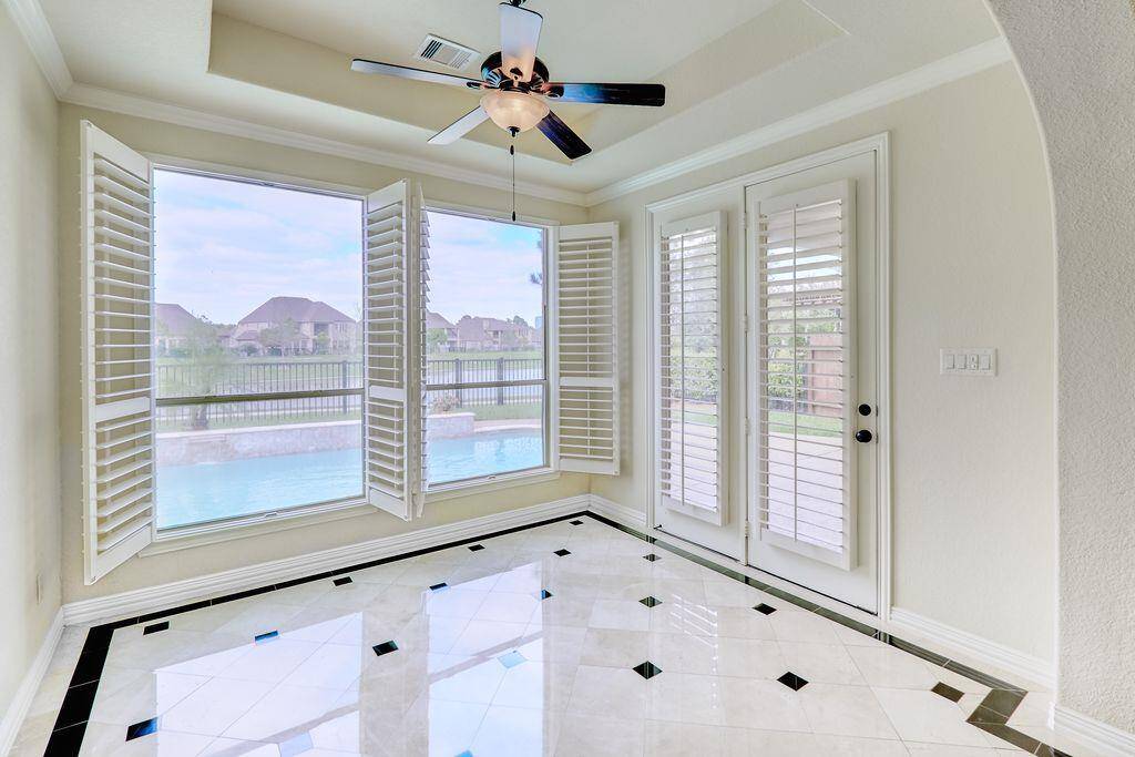 Sunny breakfast room offers beautiful views of the lake and pool, while Plantation shutters elegantly adorn the windows and offer shade during the middle of the day.