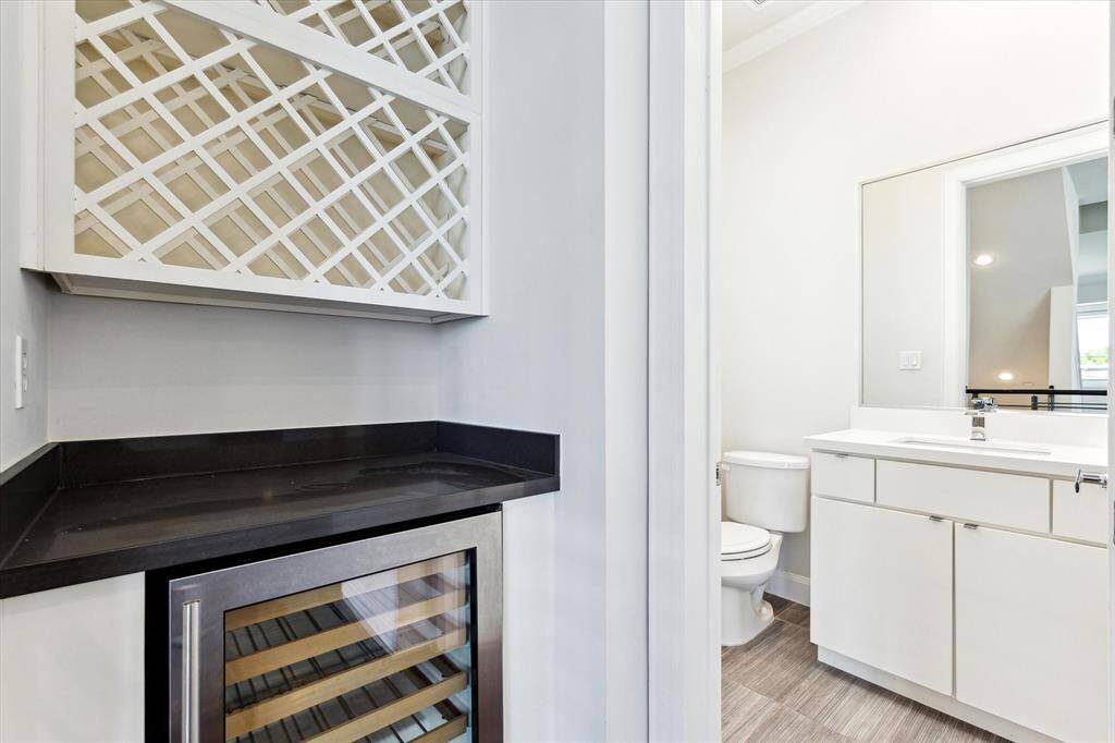 Convenient second-floor half bathroom featuring a dedicated wine space—perfect for entertaining or quick access