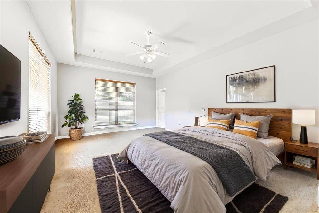 SPACIOUS PRIMARY BEDROOM WITH COZY CARPET FLOORING, TRAY CEILING, AND HUGE WINDOWS THAT ALLOW ABUNDANT NATURAL LIGHT. **This room has been virtually staged.