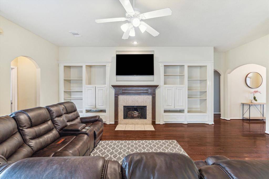 FAMILY ROOM WITH A GAS LOG FIREPLACE AND CUSTOM BUILT-IN SHELVES AND CABINETS.
