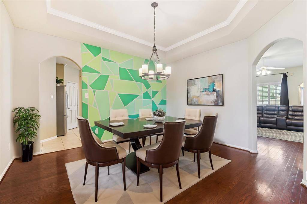 SPACIOUS DINING ROOM HAS DIRECT ACCESS TO KITCHEN AND LIVING ROOM - FEATURING A STUNNING TRAY CEILING, WOOD FLOORS, AND AN ARCHED ENTRYWAY. **This room has been virtually staged.