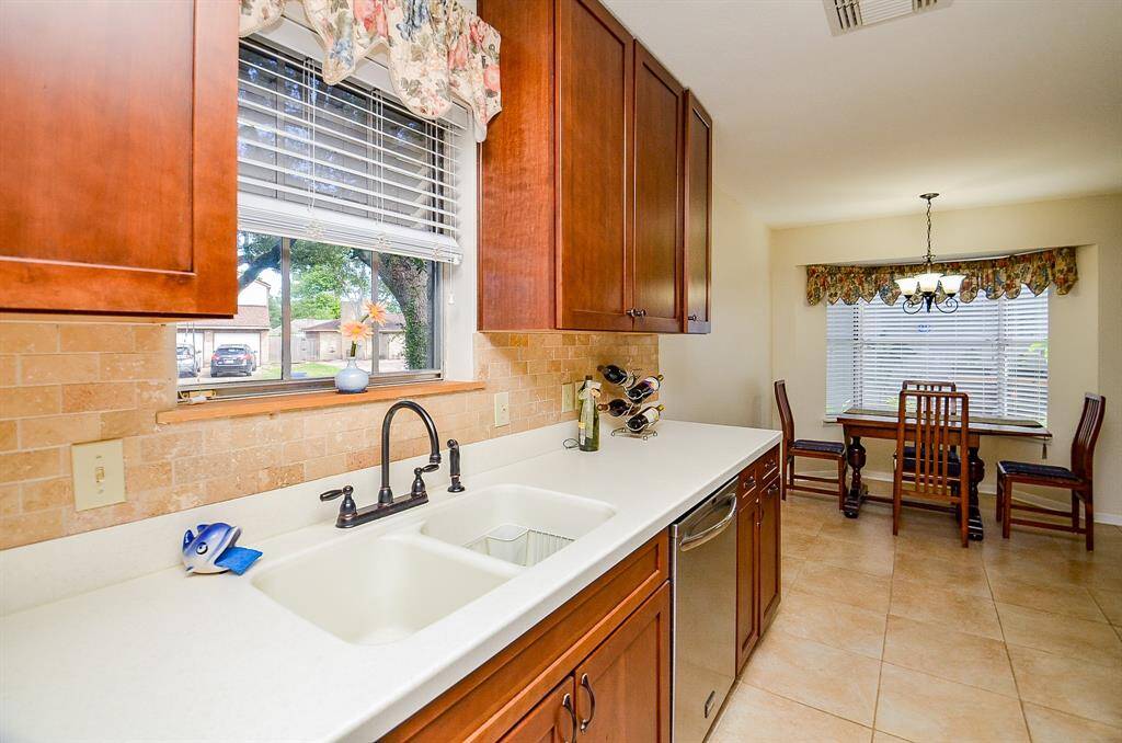The kitchen window overlooks mature trees.