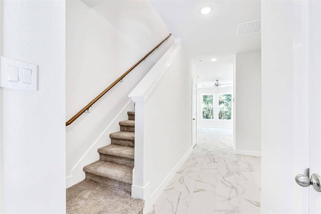 View of entry with stairs to your left and a half bathroom to your right. Look at that great natural light coming from your forest view.