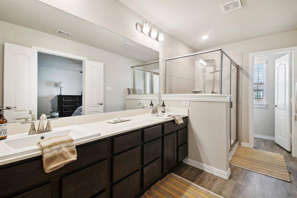 Primary bathroom features a walk-in closet, dual sinks, and a luxurious walk-in shower