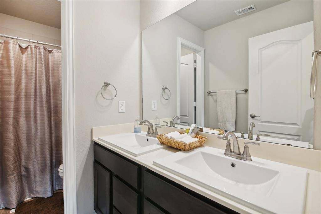 The secondary bathroom is equipped with a tub/shower combo and dual sinks