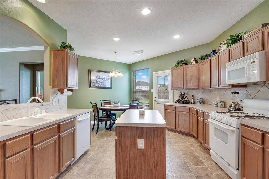Expansive kitchen featuring ample cabinetry, an island, and a cozy breakfast nook.