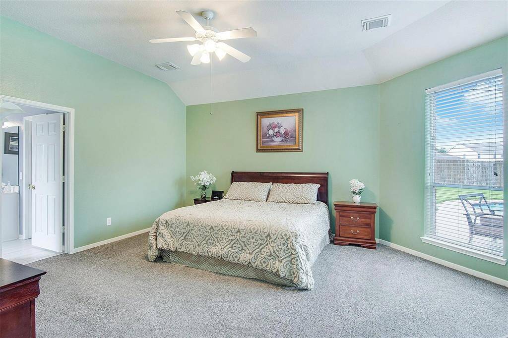 Luxurious main bedroom with plush carpeting, and abundant natural light for a cozy retreat.