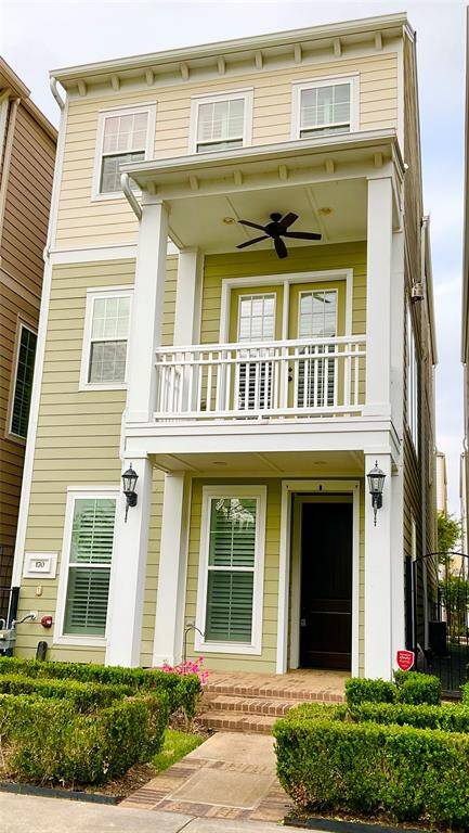 A charming three-story, single family home features a welcoming front porch with a ceiling fan, crisp white trim, and a neatly landscaped front with hedges. The facade is accented with multiple windows, providing ample natural light. Enjoy a lock and leave lifestyle!