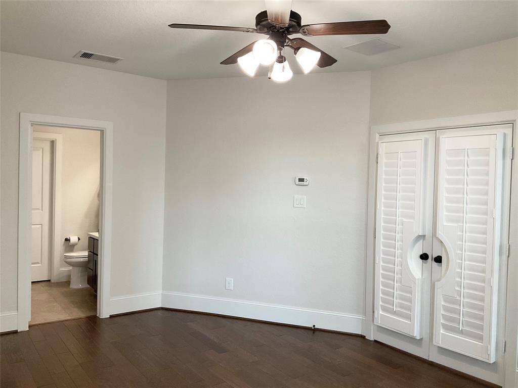 The 1st floor flex room features hardwood floors, a ceiling fan with lights, and white walls. It has an ensuite bathroom and spacious closet with double doors and shutters for privacy. Ideal for natural light and a room you can use for any purpose located off the entry it serves as  guest room, home office, playroom exercise room.   You decide!