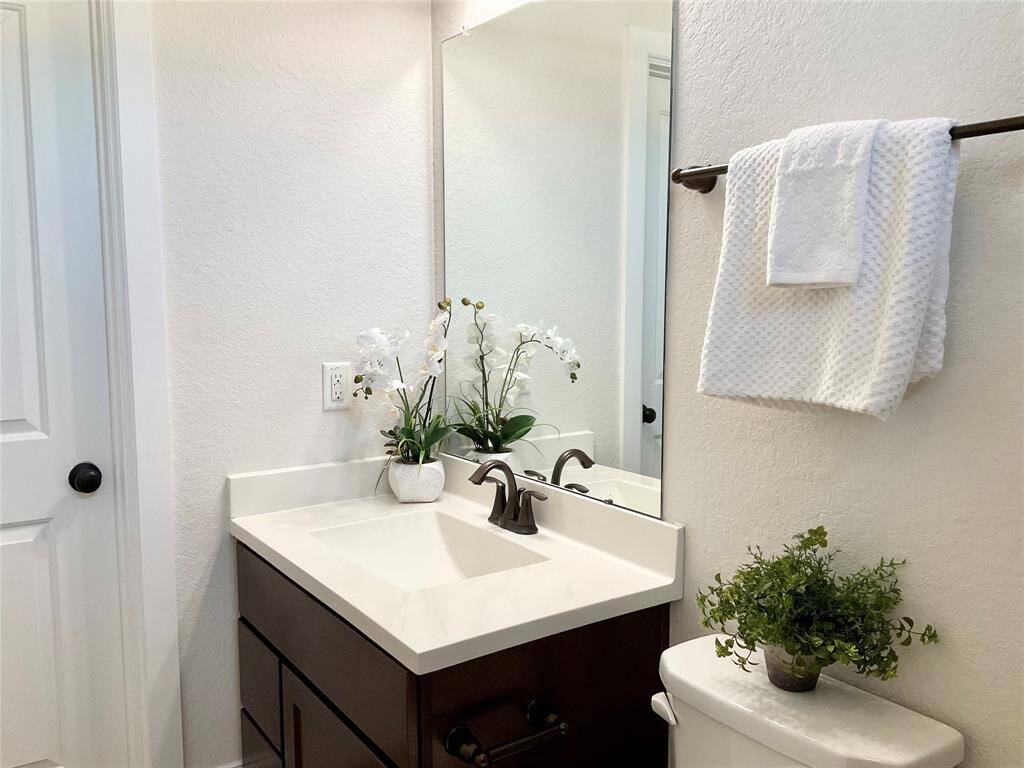 A modern bathroom with a clean design, featuring a white countertop with a sleek faucet. The  guest bathroom offers a tub/shower combination, a full walk in closet and neutral wall tones for a fresh, inviting atmosphere.