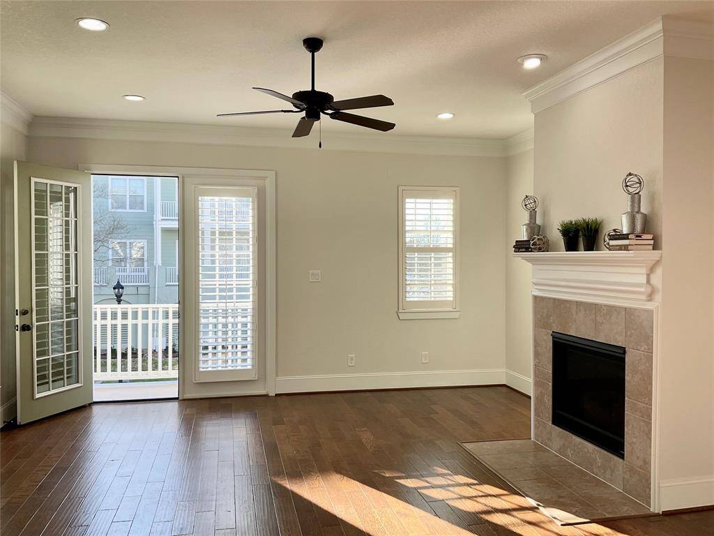 The family room offers a gas log fireplace, double French doors to the balcony and sunset views of Lake Woodlands.