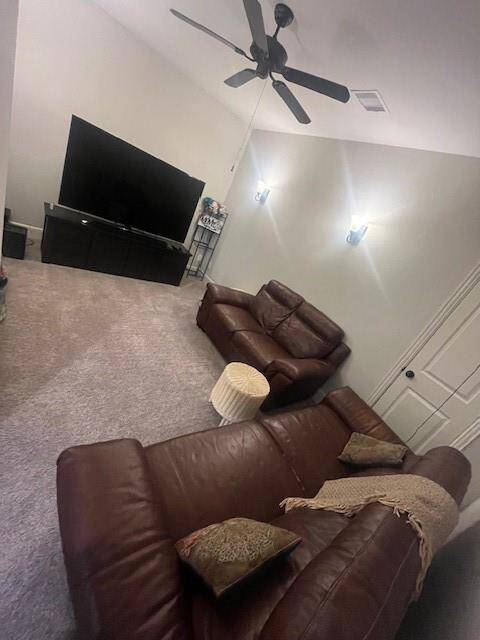 Cozy upstairs media room designed for relaxation and entertainment. Outfitted with plush leather seating, soft carpet underfoot, and ambient wall lighting, this space is perfect for movie nights or game day gatherings. A ceiling fan ensures year-round comfort, while the large TV and sleek console make this an ideal spot for enjoying your favorite shows in comfort and style.