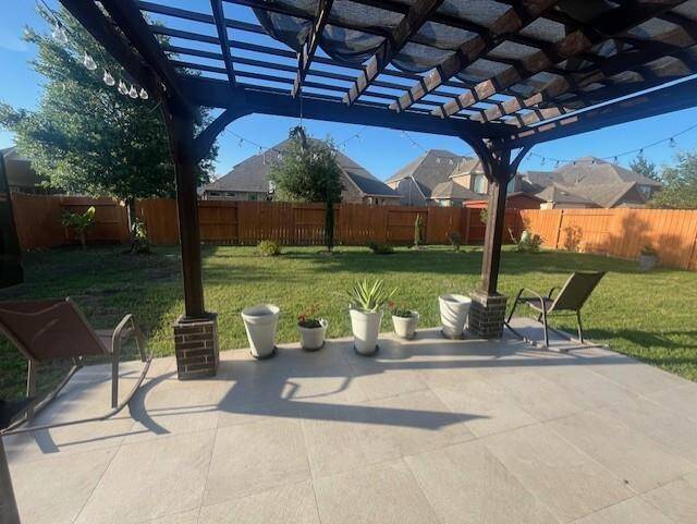 Step out onto a beautifully tiled patio under a stylish wooden pergola, perfect for unwinding or entertaining. String lights add a warm, ambient glow for evening gatherings, while the open layout offers ample space for outdoor seating or dining. Lined with charming potted plants and overlooking a spacious, fully fenced backyard, this serene setting is ideal for enjoying sunny afternoons or starry nights in comfort and privacy.