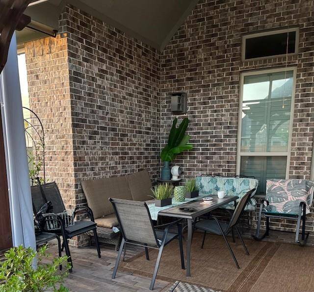 A cozy outdoor patio with a brick wall backdrop. Enhancing the inviting atmosphere for outdoor relaxation or entertaining.