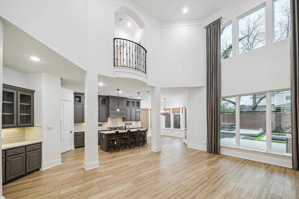 This spacious home features a modern, open-concept layout with high ceilings and abundant natural light. The kitchen boasts sleek cabinetry, an island with seating, and stylish pendant lighting. Large windows offer scenic views of the backyard, complete with a pool/oversized spa, perfect for entertaining and relaxation.