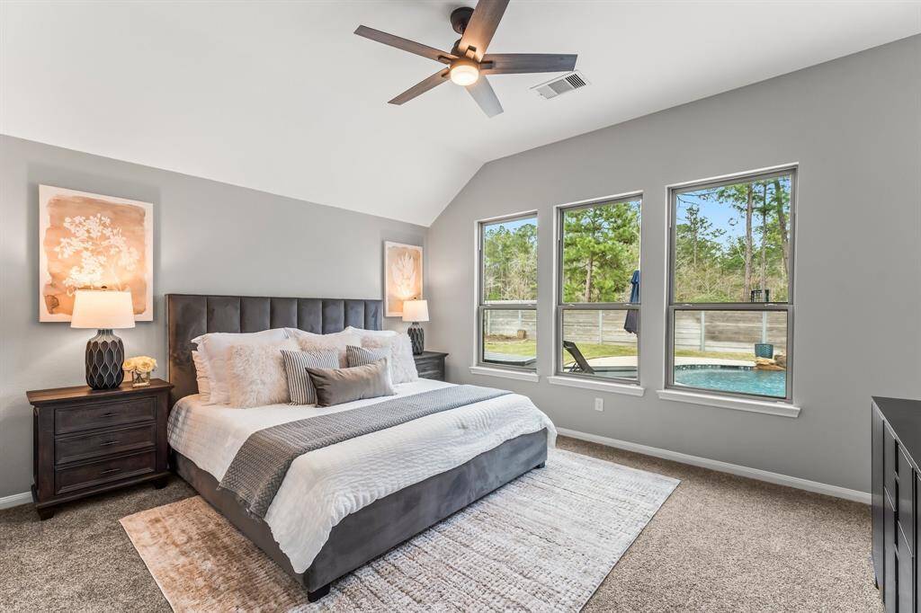 This spacious primary bedroom features high ceilings, large windows with backyard and pool views, and abundant natural light. Recently updated carpet adds a fresh touch.