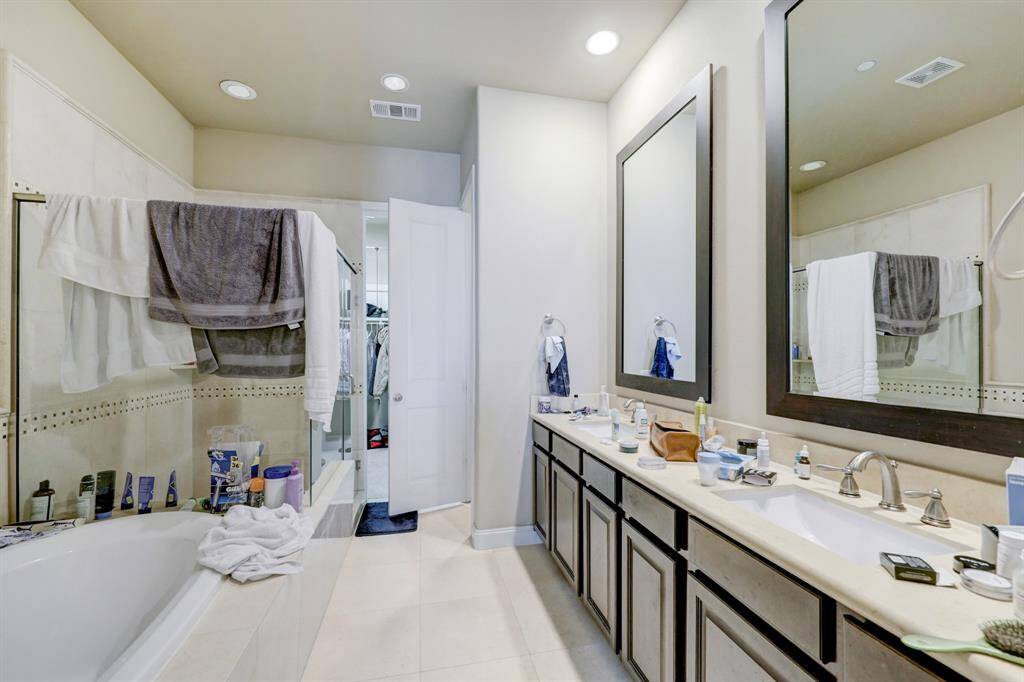 Large primary bathroom with double vanity, separate tub and shower