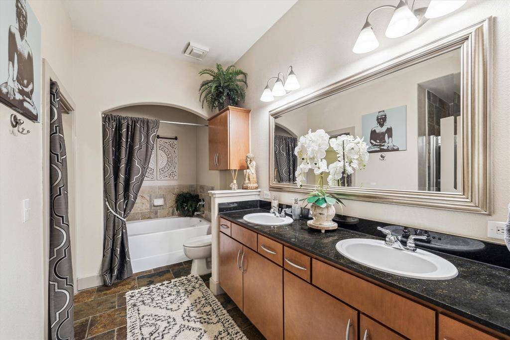 This primary bathroom is well-appointed. It includes both a soaking tub and a separate glass enclosed shower as well as dual sinks