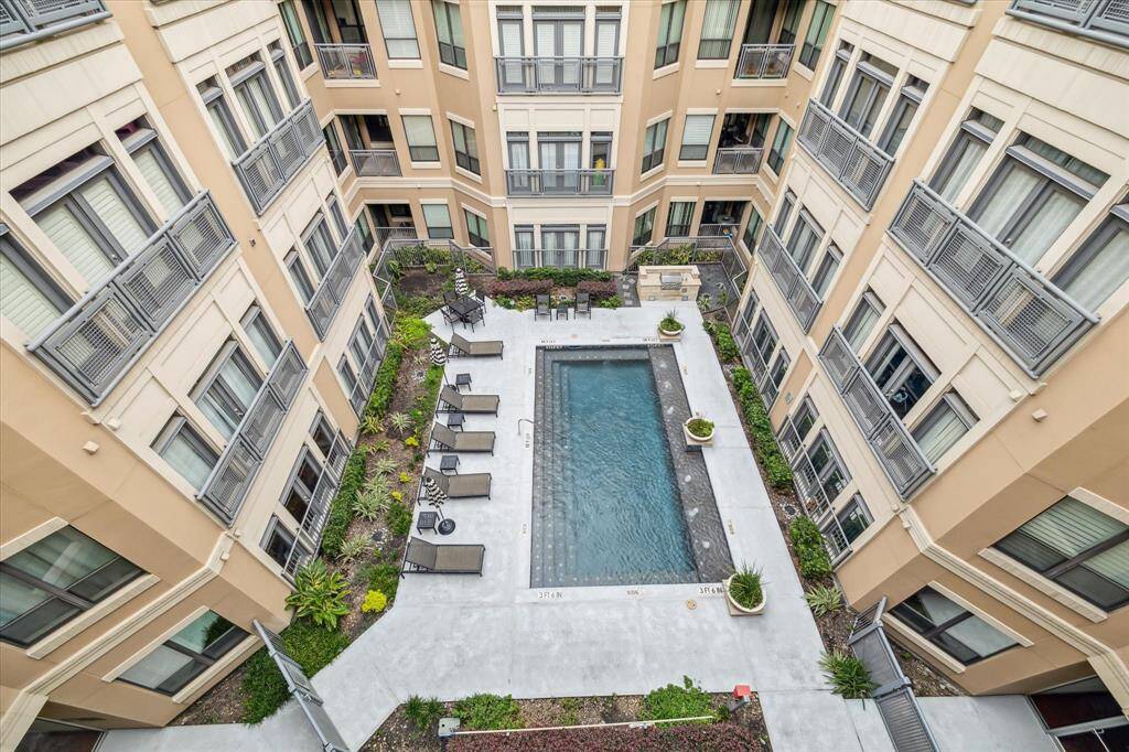 Relax in the serene, landscaped courtyard featuring a resort-style pool and ample lounging space