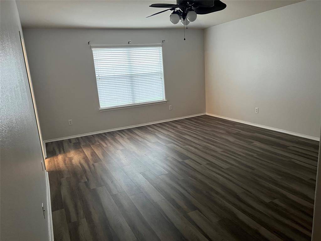 Primary bedroom with beautiful flooring and ceiling fan.