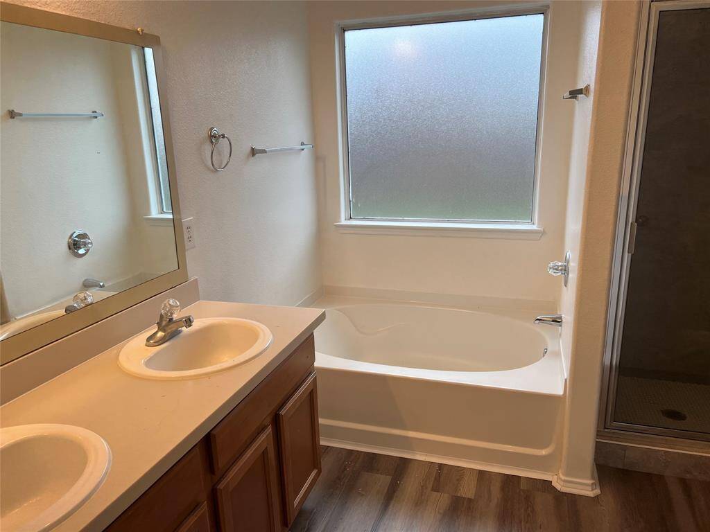 Primary bathroom features double sinks, soaking tub and a separate shower.