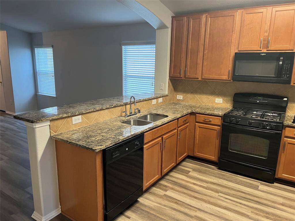 Kitchen offers, granite counters with undermount sink, black appliances and 5-burner gas cook top.